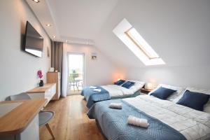 a bedroom with two beds and a living room at Viss Mielno in Mielno