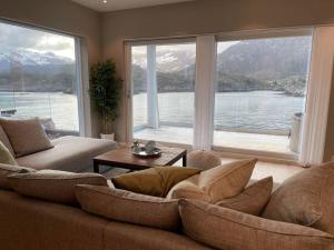 sala de estar con sofá y ventana grande en Eksklusiv leilighet med spektakulær utsikt, en Kabelvåg