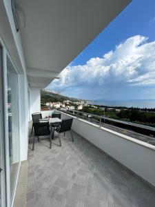 a balcony with a table and chairs and a view of the ocean at Apartmani Tomaš in Tučepi