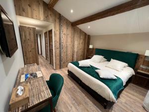 ein Schlafzimmer mit einem großen Bett und einem Tisch in der Unterkunft Les Cornettes in La Chapelle-dʼAbondance