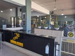 a restaurant with a counter in the middle of a building at THE BLYDE Holiday Apartments in Pretoria