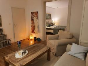 ein Wohnzimmer mit einem Sofa, einem Tisch und einem Bett in der Unterkunft Wohnen in der Bürgermeistervilla in Hamburg