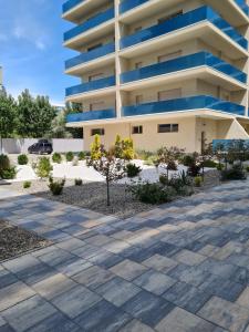 a building with a sidewalk in front of it at Matteo 2 Apartments Marina Surf Residence, Mamaia Nord - Năvodari,1 vedere frontala,2 cu vedere laterala la mare in Năvodari