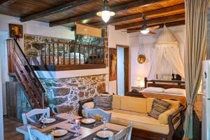 a living room with a couch and a bed and a table at "PefkoPetro" Traditional House in Keramotí