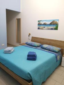 um quarto com uma cama azul com duas toalhas em Il Vicoletto em Pisticci