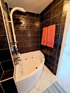 a bath tub in a bathroom with black tiles at Apartman Koli Opatija in Opatija