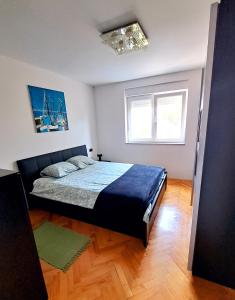 a bedroom with a bed and a window at Apartman Koli Opatija in Opatija