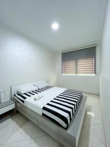 a bedroom with a large bed in a white room at Rif Appartment in Al Hoceïma