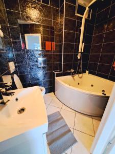 a bathroom with a tub and a toilet and a sink at Apartman Koli Opatija in Opatija