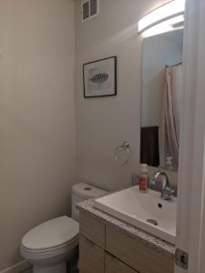 uma casa de banho com um WC branco e um lavatório. em Harbison em Winnipeg