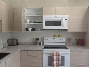 a kitchen with a white stove and a microwave at Harbison in Winnipeg +9 photos