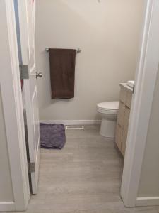 bagno con servizi igienici e asciugamano. di Harbison a Winnipeg