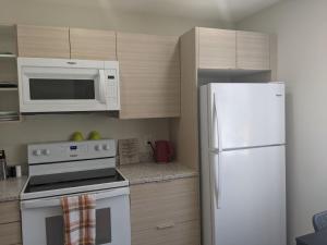 a kitchen with a white refrigerator and a microwave at Harbison in Winnipeg