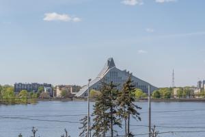 a large building next to a body of water at Cosy studio with river view in Rīga