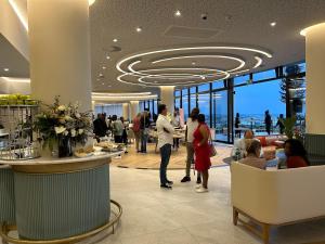 a lobby of a hotel with people standing around a counter at Exec Oasis @Ellipse in Midrand