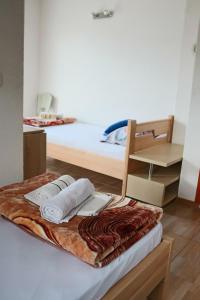 a bed with two towels on top of it at Big Mama's Apartments in Konjic