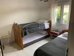 KondárainaにあるKONTI VILLAのベッドルーム1室(二段ベッド2台、窓付)が備わります。