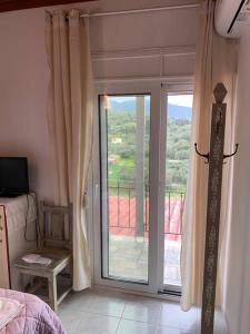 a bedroom with a sliding glass door to a balcony at KONTI VILLA in Kondáraina