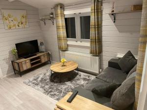 a living room with a couch and a table at Country Cabin Omagh in Omagh