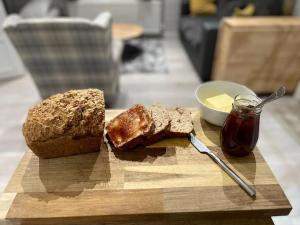a cutting board with a loaf of bread and a bowl of butter at Country Cabin Omagh in Omagh