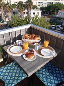 een tafel met ontbijtproducten op een balkon bij La mer in Balaruc-les-Bains