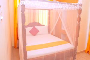 1 dormitorio con litera y dosel en Home Away from Home, en Mombasa 3 fotos más