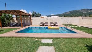 Kalmet的住宿－Kallmet Villa，庭院内的游泳池配有椅子和遮阳伞