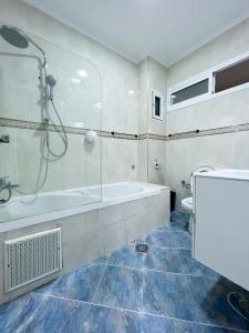 a bathroom with a tub and a shower and a toilet at Rif Appartment in Al Hoceïma