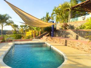 a swimming pool with a hammock next to a house at Cerrito Encantado! Hidden Escape with Amazing Views 