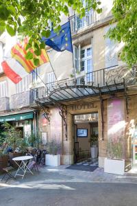 un edificio con balcón y banderas. en Hôtel de France en Aix-en-Provence