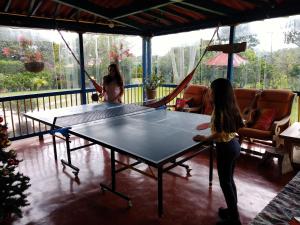 two women playing a game of ping pong on a table at Finca El Topacio Circasia-Quindio in Circasia