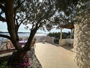 a patio with a tree and a table and chairs at Villa Porthos in Hvar