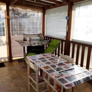 una veranda riparata con griglia e tavolo di Marennes mobilhome 46 Domaine des pins a Marennes
