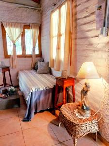 Schlafzimmer mit einem Bett, einem Tisch und Fenstern in der Unterkunft La Pepita in Ciudad Lujan de Cuyo