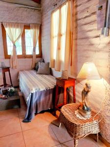 a bedroom with a bed and a table and windows at La Pepita in Ciudad Lujan de Cuyo