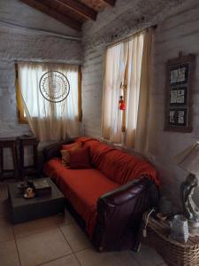 a bedroom with a leather couch and a window at La Pepita in Ciudad Lujan de Cuyo