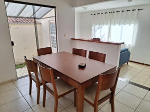 a dining room with a wooden table and chairs at Casa espaçosa em Poços de Caldas in Poços de Caldas