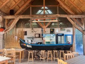 a boat on the wall of a restaurant with stools at Nena Art Resort in Dunavăţu de Jos