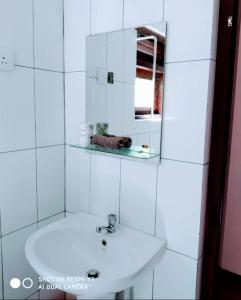 a white bathroom with a sink and a mirror at Beach House Kalukatiya - Family Villa, Seaview Room, Garden Room in Dickwella