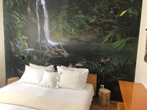 a bedroom with a waterfall mural on the wall at Apartmani Maretimo in Primošten