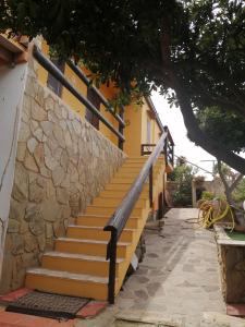 a set of stairs next to a yellow building at La casa di Mo' in Torre Dei Corsari