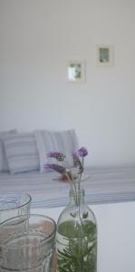 a glass vase with purple flowers in it on a table at Studio Ornos in Ornos