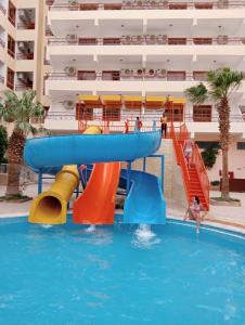 a water slide in a swimming pool next to a apartment at Empire Hotel Aqua Park - Couples and Families in Hurghada