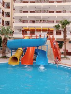 a water slide in a swimming pool next to a apartment at Empire Hotel Aqua Park in Hurghada