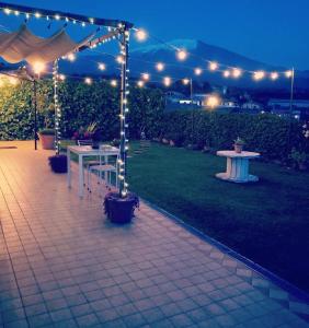 a patio with a table and a tent with lights at Good Morning Etna in Bronte