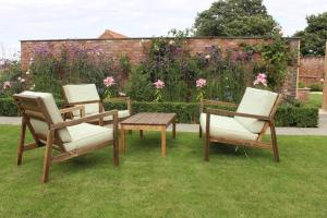 a couple of chairs and a table in the grass at Boutique double room with countryside views in Wilby