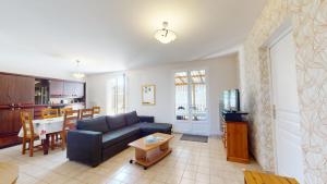 una sala de estar con un sofá y una mesa en La Dolce Vita proche des plages, en Saint-Hilaire-de-Riez