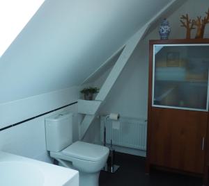 a white bathroom with a toilet and a staircase at Entre en Baie ! in Pontaubault