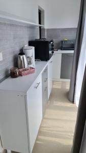 uma cozinha com armários brancos e uma bancada em Pomiculturii Residence 8 em Timisoara