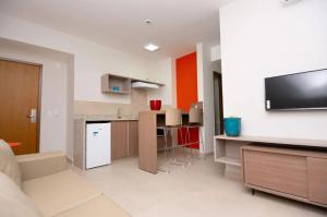 a living room with a tv and a kitchen at Apartamento 2 quartos Lazer Completo in Caldas Novas